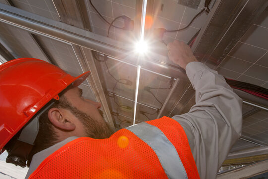 Solar photovoltaic installer working on power connections for a PV array
