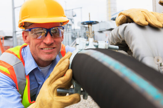 Engineer at electric power plant examining hose for water supply to the water storage tank