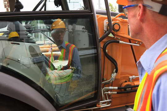 Engineer at electric power plant looking at backhoe