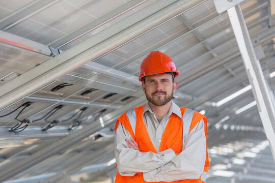 Power engineer standing underneath solar photovoltaic array