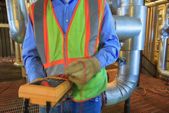 Engineer in electric power plant using a voltmeter
