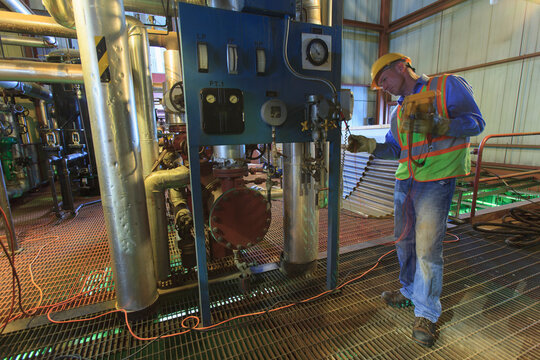 Engineer in electric power plant using a voltmeter