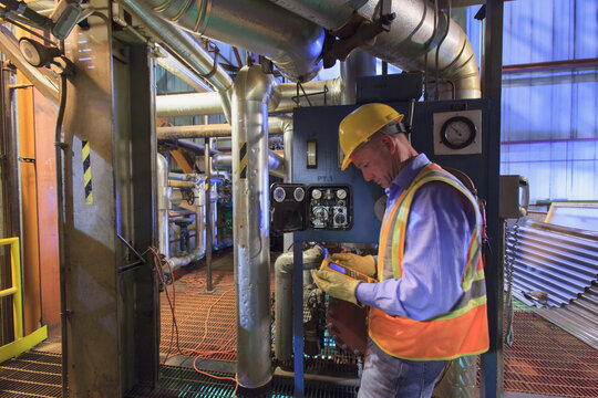 Engineer in electric power plant using a voltmeter to verify sensor readings