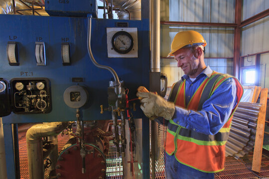Engineer in electric power plant using a voltmeter to verify sensor readings