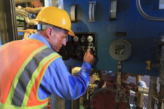 Engineer in electric power plant reviewing sensor readings
