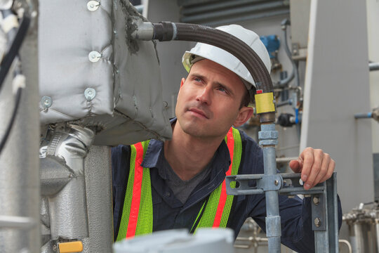 Industrial engineer examining high temperature sensor connections at a power plant