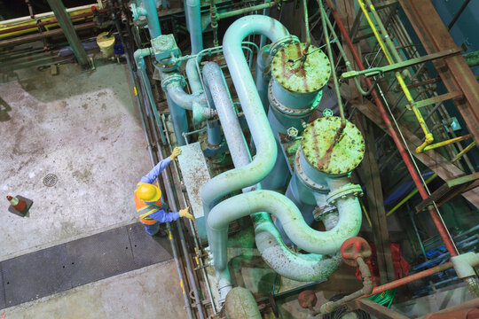Engineer in gas turbine electric power plant exhaust gas and condensation process room reviewing