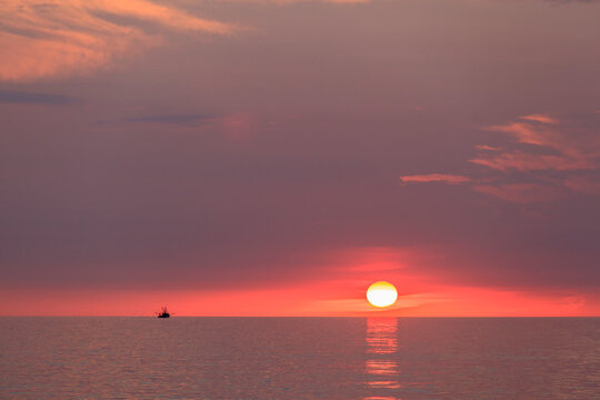 Sunrise over ocean on Block Island with fishing trawler