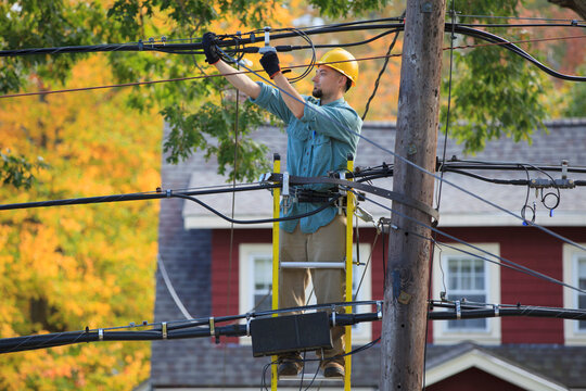 Lineman working on cables at power pole