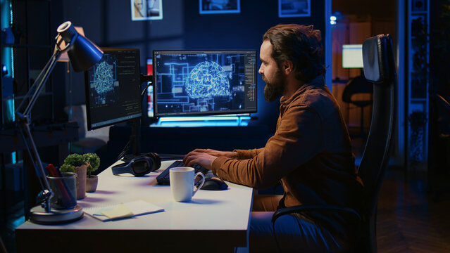 Computer scientist writes code on PC to visualize artificial intelligence neural networks. Remote IT worker runs AI script for information processing from personal office.