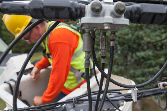 Cable lineman reaching for tools in a bucket lift