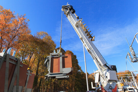 Crane moving high voltage transformers at power plant
