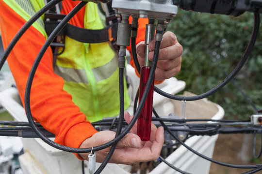 Cable lineman using nut driver to remove connection from a bucket truck
