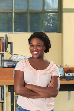 Smiling engineering student in an electronics classroom