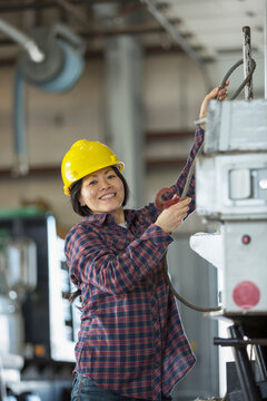 Female power engineer securing cable to equipment truck