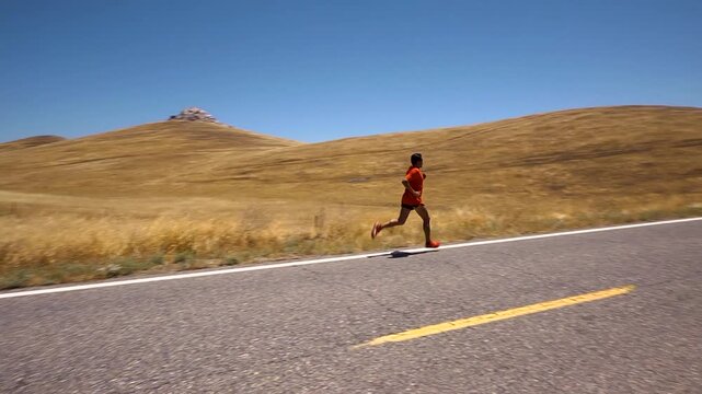 long distance runner training on a lonely highway