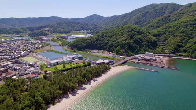 気比の松原（福井県）の海岸線と松林、山並みの風景、ゆっくり前進・上昇するドローン空撮 / Kehi no Matsubara coastline with pine forest and mountains in Fukui, aerial view tracking forward and upward