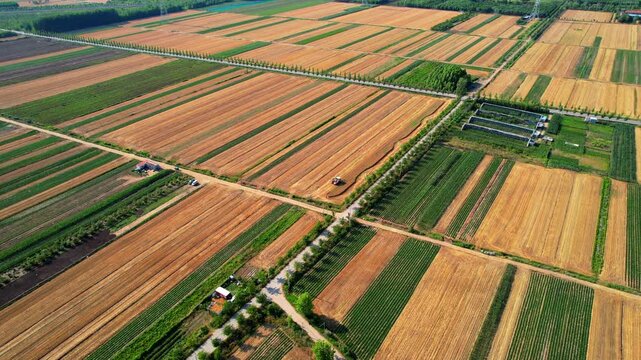Aerial shot of vast agricultural land with neatly divided plots, showing mixed crops and rural infrastructure.