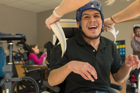 Boy with Spastic Quadriplegic Cerebral Palsy using using his helmet and strap