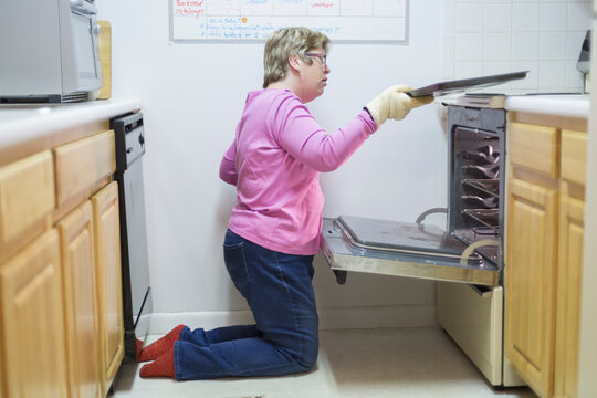 Woman with Autism removing tray from oven