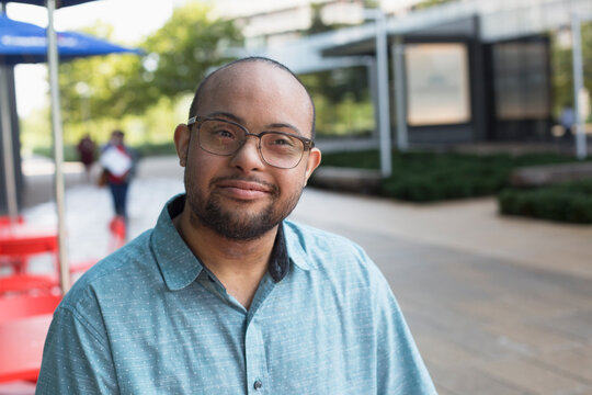 African American man who has Down Syndrome standing at sidewalk cafa&Eacute;a