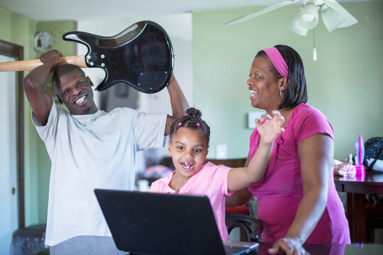 Man with Williams Syndrome playing a guitar and family laughing