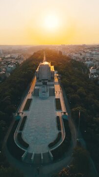 Sunrise bathes the National Monument at Vitkov Hill in golden light. The grand memorial dedicated to Jan Zizka stands majestically amidst serene surroundings, offering stunning views of Prague.