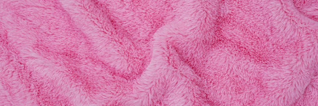 Soft pink blanket displays a textured pattern on a flat surface in a casual indoor setting during daytime
