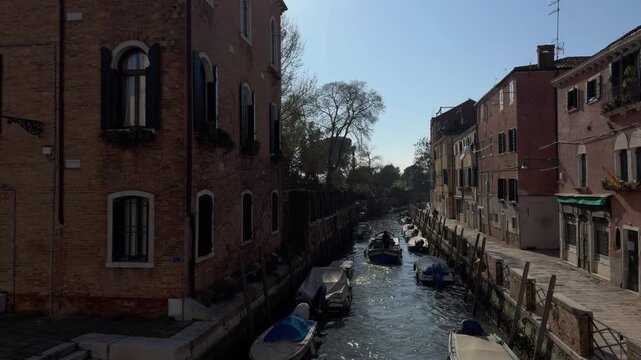 Motorboat cruising through narrow Venetian canal street