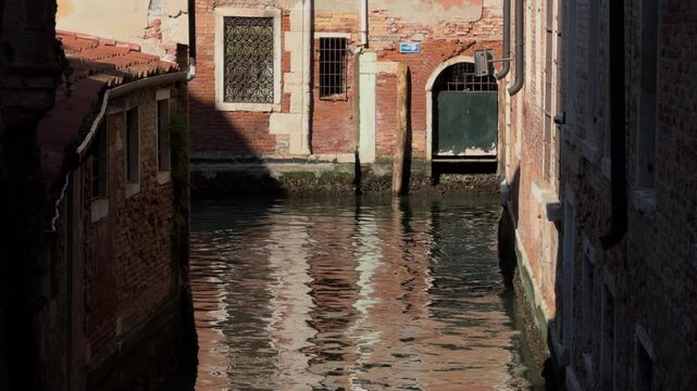 Slow motion canal between historic Venetian buildings