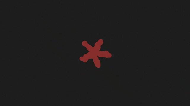 Red ink spot transforming into an asterisk symbol shape against dark grey grainy background.