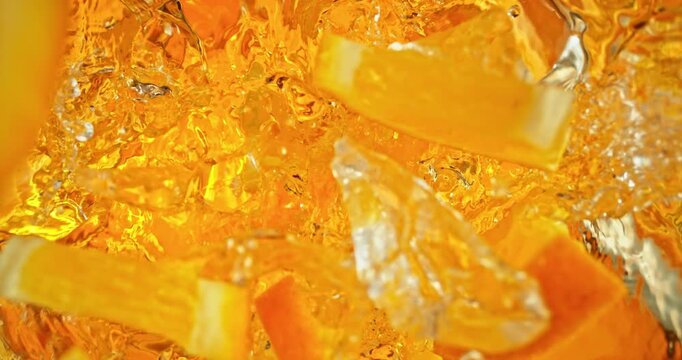 Super slow motion 1000fps video of fresh orange slices and crushed ice falling into rippling water, creating a sparkling splash, perfect for drink, cocktail and summer visuals.