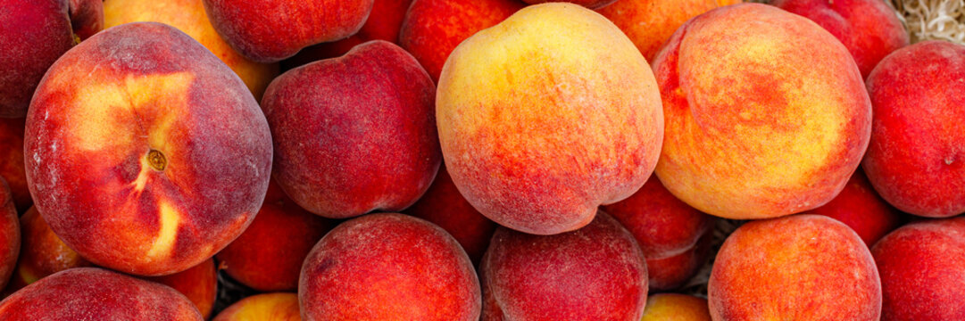 Fresh peaches sit on display at a local market during summer harvest season in the afternoon sunlight