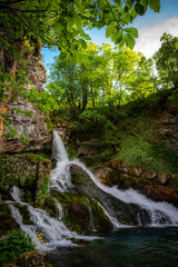 Crnjak waterfall cascading over mossy rocks into pool surrounded by lush green forest, Bijela, Savnik, Montenegro © Marina