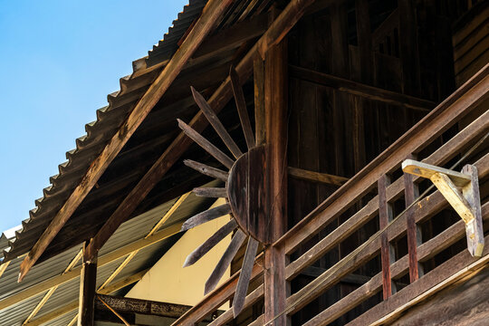 Old traditional wooden house balcony featuring unique sunburst wood carving decoration and designed to prevent people from climbing over balcony. Sunburst design by wood craft. Traditional lifestyle
