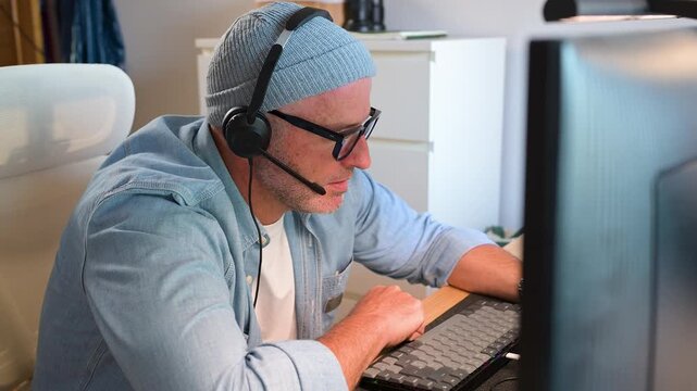 Call center agent wearing headset typing on computer