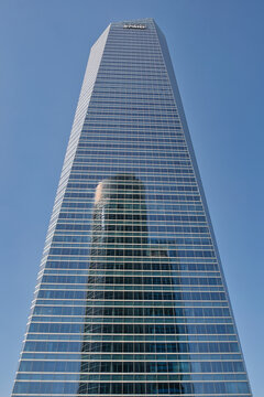 MADRID, SPAIN - JUNE 6, 2026: Low view of Torre de Cristal skyscraper in the Cuatro Torres Business Area financial district of Madrid, with the KPMG logo visible at the top and another tower reflected