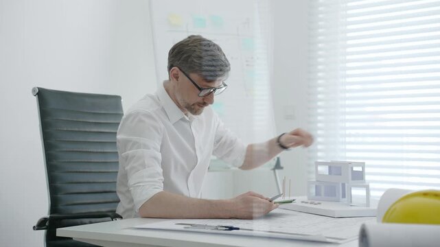 Architect designing residential building model in office, creating detailed blueprints and plans for urban development, focusing on construction project planning and creative architectural solutions