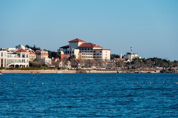 Fototapeta premium European style seaside buildings with blue ocean under clear sky in Qingdao, China
