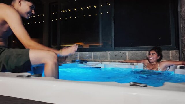 Woman relaxing in a hot tub with color changing lights