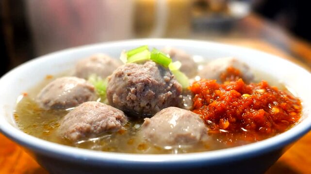 Delicious Indonesian Bakso Soup with Spicy Chili Sauce, Traditional Meatball Dish.