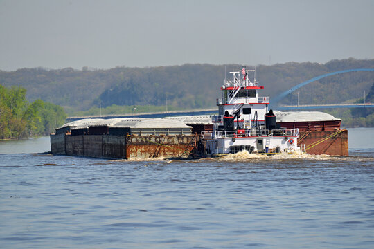 Rear view of a Tug boat pushing a large set of barges North up the Mississippi River