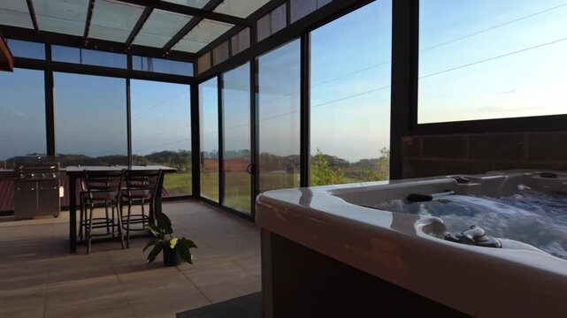 Bubbling hot tub in a modern sunroom at sunset
