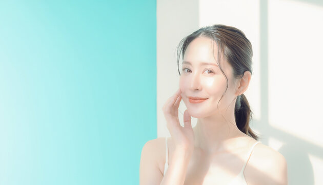 Beautiful Asian woman touching her cheek for skincare concept 頬に触れるスキンケアコンセプトの美しいアジア人女性
