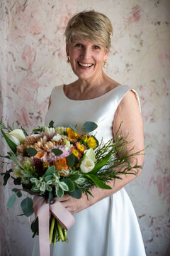Elegant bride holding vibrant bouquet.