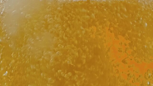 Golden beer or soda pours and foams on green screen, with bubbles and froth for beverage ads, bar scenes, parties, and VFX compositing.