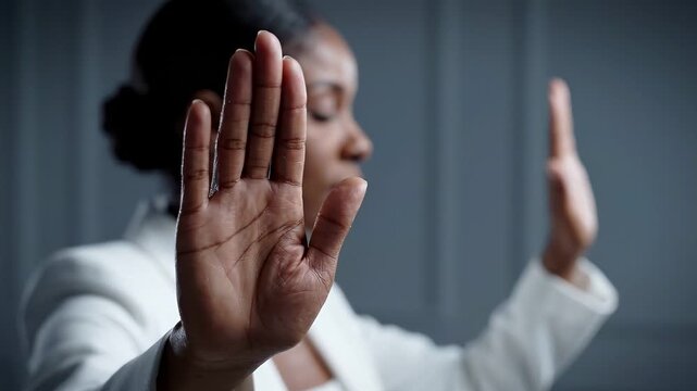 Woman with eyes closed making stop gesture with hands