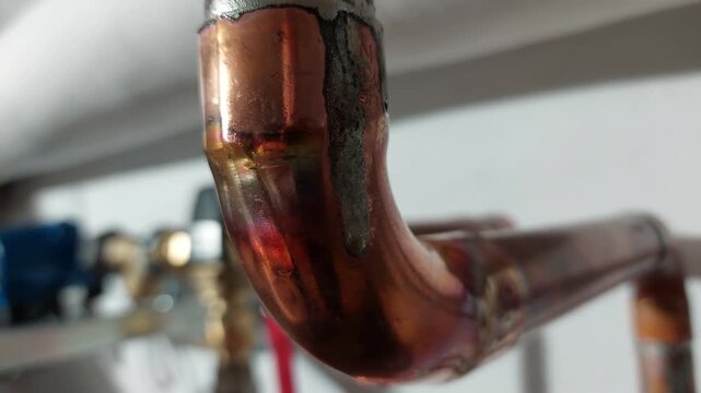 Close up of soldered copper pipe elbow in domestic heating or water system