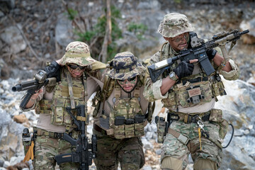 Fototapeta premium Special forces soldiers in camouflage assist a wounded comrade during a tactical training exercise