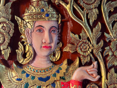 Close-up of a gilded wood carving of a guardian deity at a temple in Chiang Mai